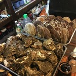 居酒屋せいご - カウンターに並べられた岩ガキとホタテ