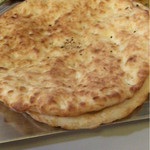 マディナ カレーレストラン - 丸いナン。ずっしりしたパンのような感じ。