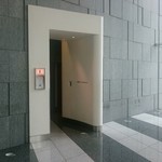 エディション・コウジ シモムラ - ビルの壁に抜け道のような白い入口