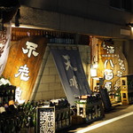 ビストロ割烹 YAOYA - 商店街を北へ少し進むと暗がりの中に酒瓶がライトアップされた店があります。