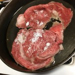 登喜和 - 鉄鍋に牛脂を引き、十分熱したところで分厚くスライスした肉を焼きます。