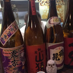 よね家 - 焼酎一升瓶の隙間からチラ見えの大将