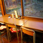チェブ カフェ - 学校の机とテーブルが窓に向かって配されている