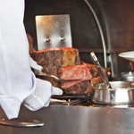 ロウリーズ・ザ・プライムリブ 大阪 - うーん、すごく大きいお肉だねぇ♪希望の焼き加減やカットを聞かれるので、ボキら4人は焼き加減は全員ミディアムレアに。カットは、お店の方のおすすめで、2人は薄切り、2人は厚切りにして食べ比べしてみることに