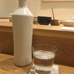 鮨 おくの - お冷は白釉薬のボトルで提供