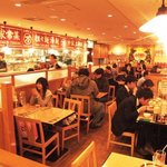 万豚記 - 男女問わず大人気のお店です。活気あるキッチンが眺められる店内。いち押しの料理品目が並ぶ壁に注目！