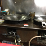 華光軒 - 厨房の左の方です。初めて見る形の大きな中華鍋です。（2016.11 byジプシーくん）