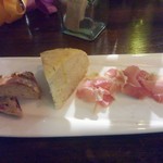 ワイン食堂 cor. - お通しは４２０円(税込) 左からそばのオランチベーカリーの何か柑橘類のピール入りハードパン、癖のない自家製フォカッチャ、しっとりとしたプロシュート。