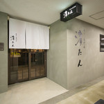 牛タン専門店 濱たん - コンクリートに屋号だけのモダンな入口。白い暖簾が目印です。