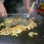広島風お好み焼 くいしん坊 - ホルモンうどんを作る（キャベツとピリ辛のタレを入れて豪快に混ぜる）