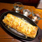 地酒喝采 かも蔵 - 栃尾ピザ（￥771）。新潟名物・栃尾の厚揚げを洋風に仕上げた一品