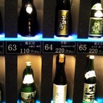試 - 壁一面日本酒の瓶が並んでいます。