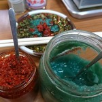龍園 - タレと調味料  緑色がニンニク  赤色は唐辛子