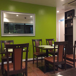 オリエンタルキッチン アンジュナ - グリーンの壁が素敵。椅子とテーブルの茶色とのコントラストがいい。