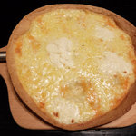居酒屋 たかまる - 4種チーズピザ（780円）金属色の棒はピザカッターの柄