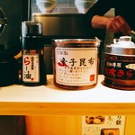 らー油肉つけうどんの南哲 - 左から生姜、香ばしさ重視のらー油、辛子昆布、火吹きらー油。