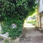 ガレージ ブルーベル - 踏切手前を左折すると鬱蒼とした木々に囲まれた古民家が…。英語の看板もあります。やけにその先が
      光っています。