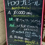 トロワプレジール - 店前にあったランチのプレートです。 今日のランチはどんな感じなんでしょうね。 ランチは２種類あるようです。トロワプレジールへようこそ 気軽にワインと食事はいかがですか？ ＜ワイン＞ 　ボトル　２,８０