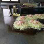 焼助 - 調理中のお好み焼き