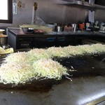 焼助 - 調理中のお好み焼き