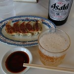 三久ラーメン - 食堂のコップみたいなので飲むビールも田舎ぽくて好き。カウンターの化粧板を養生テープで貼ってあるあたりが、また、味わい深い。。