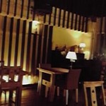 ル・モニュマンブルー - テーブル席部分。天井がたかく、照明はダーク。落ち着く。