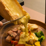 The fresh and delicious "Hokkaido Cheese Raclette" (a plate of grilled cheese, vegetables, and thick-sliced bacon)