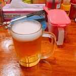 しまや - 生ビール小  後ろの赤い蓋は福神漬、青い蓋はキャベツの酢漬