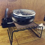 炭火焼肉 康 - 店内カウンター席の七輪（お洒落な七輪ですね。）