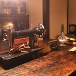 森彦 - 1階のテーブル席は4人掛。アンティークのミシンが使い込まれたテーブルの中央に置かれています。