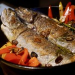 おこもり 山女魚 - 山女魚の香草焼：獲れたての山女魚をローズマリーなどのハーブとともにスキレットに閉じ込め焼き上げます。