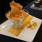 ガストロノミー ジョエル・ロブション - とうもろこしのなめらかなヴルーテ仕立て カレー風味のオイルをまとわせてについてきたポップコーンとスナック