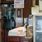 餃子会館 - 店内③
      レジ脇に目立つオレンジのステッカー