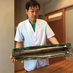 柚木元 - 大きな皿を肩に担いで登場