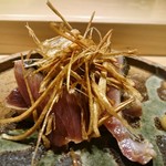 丸萬寿司 - 鰹漬け　揚げ千切りエシャロットが添えられています