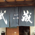 武蔵ラーメン - 鋭いデザインの紺の暖簾からは威厳と自信溢れるオーラを感じる。