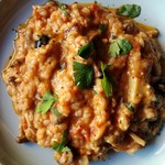 Rich tomato risotto with thickly sliced bacon