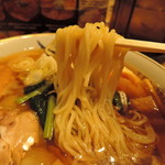 麺は中太縮れ丸麺、高加水率。 　チュルンと滑り込む、透明感ある潤い艶肌。