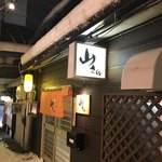 居酒屋山さん - オレンジ色の暖簾が目印