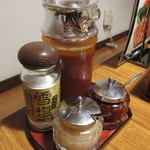 炭火焼肉たけさん亭 - テーブルの上に置かれたタレや塩、薬味