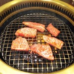 東海苑 - カルビを焼く光景。