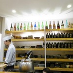 Mon ya - カウンターの中に、日本酒のボトルが美しく飾られている