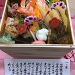 百花繚蘭 - 一の重、松葉蟹塩ゆで、子持ち鮎甘露煮、う巻き玉子、紅白ホタテ真丈、煮穴子飛龍頭(がんもどき)、さわらの柚庵焼、鰯の昆布巻き、数の子しょうゆ漬け、鯛とサーモンの龍飛巻き、鮭しょうゆ焼き、天使のえび焼き浸し、金時人参梅煮、むかご塩蒸し、鴨ロース