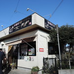 白壁で、簡素な造りの平屋建て店舗。 チープ且つ大衆的で、地味な印象。