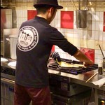 イタリアンバール ミーオ - “芭蕉せんべい”と格闘している店主(撮影した動画からの切り出し静止画)。