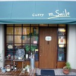 m.Smile - お店の入口です。 窓が沢山あってオープンなイメージのお店です。 幌の色とcurry m．Smileって書いている店名がいい感じですよね。 さあ、入店しましょう。