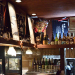 旬肴地酒 寅八 - 日本酒の一升瓶と蔵元の前掛けがオブジェとして飾られています