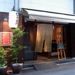 立呑み処 ひさまつ - お店の外観です。 ドアは開けっ放しになっていました。 暖簾をくぐると、店内ってなっていて、開放的な感じです。 当日のお勧めが店前のボードに書いて置いてあります。