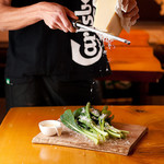FES by asobi - 平野農園の小松菜サラダ。上にかけるパルメジャーノレッジャーノはお客さんのストップがかかるまで止まりません！