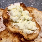 博多串焼き バッテンよかとぉ - チーズ豆腐をトーストされたバゲットに乗せて食べる、の図。